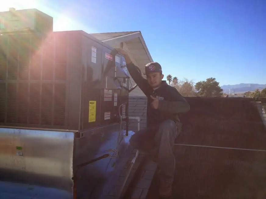 HVAC technician performing Air Duct Repair on a rooftop unit in Wheaton