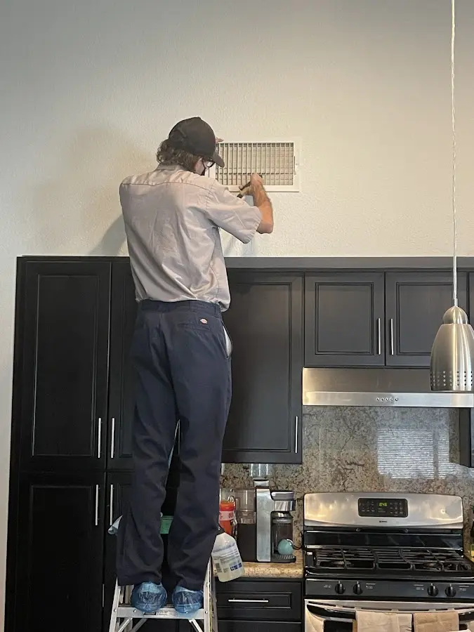 Technician inspecting an air vent during HVAC service in Wheaton